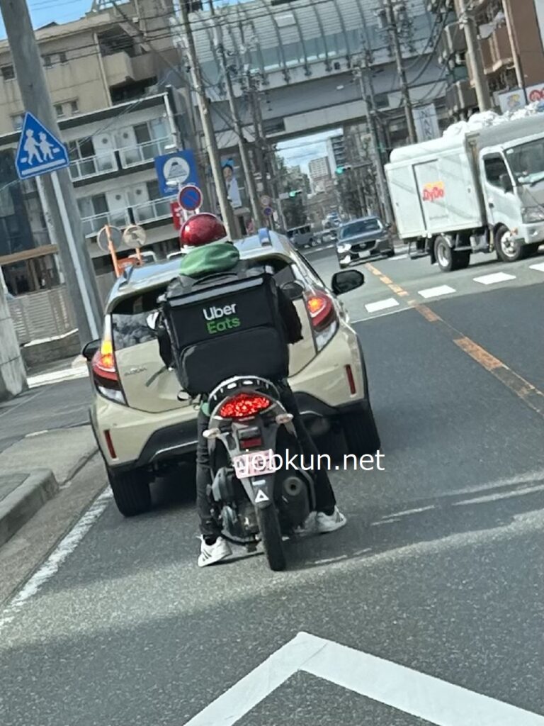 バイクに乗るウーバーイーツの配達員