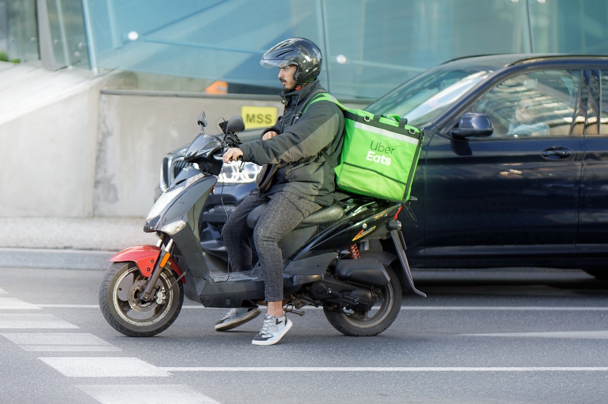 バイクに乗るウーバーイーツの配達員